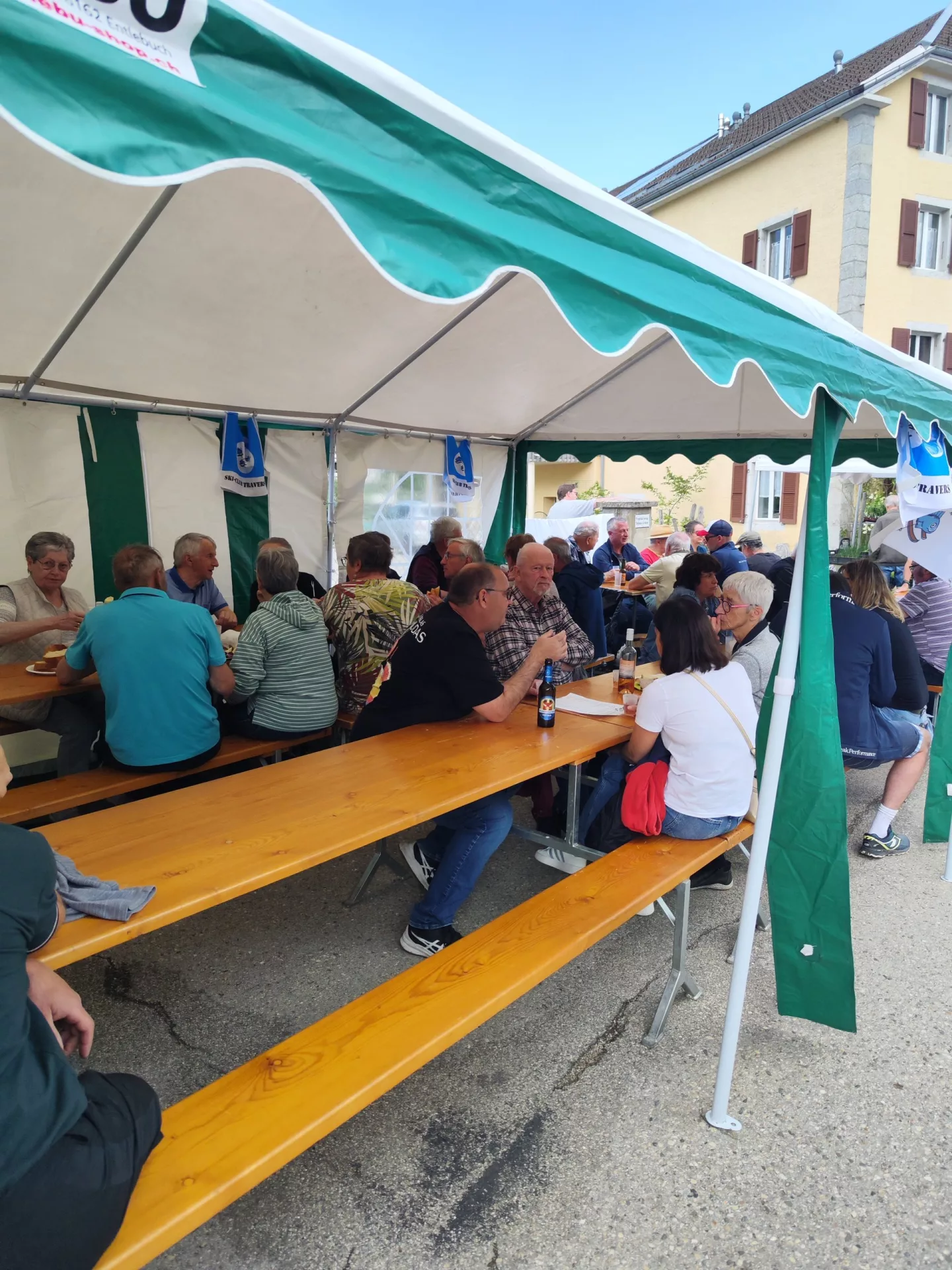 Visiteurs réunis autour des tables de restauration du marché.